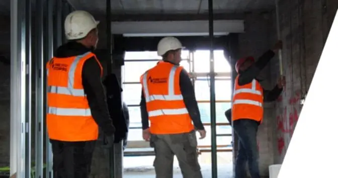 image of 3 engineers installing passive fire protection methods in a commercial premises
