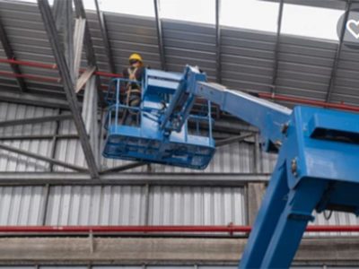 man standing on an elevating platform working on roof fire safety measures | About Us | Firestoppers